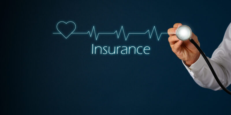 A stethoscope on the right of the photo with a heartbeat sign with the word insurance below.